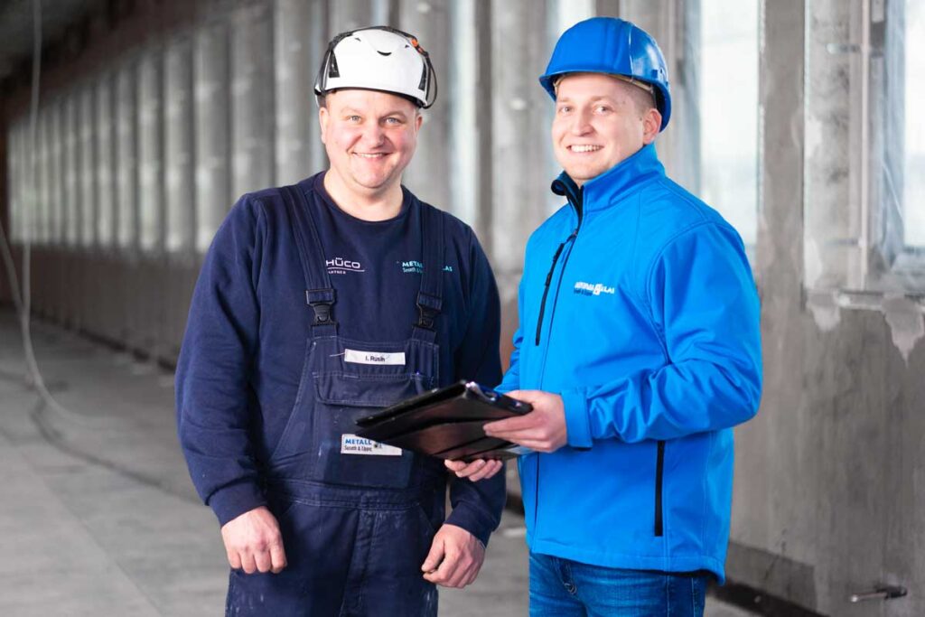 Monteur und Vorarbeiter bei einem Gespräch auf der Baustelle