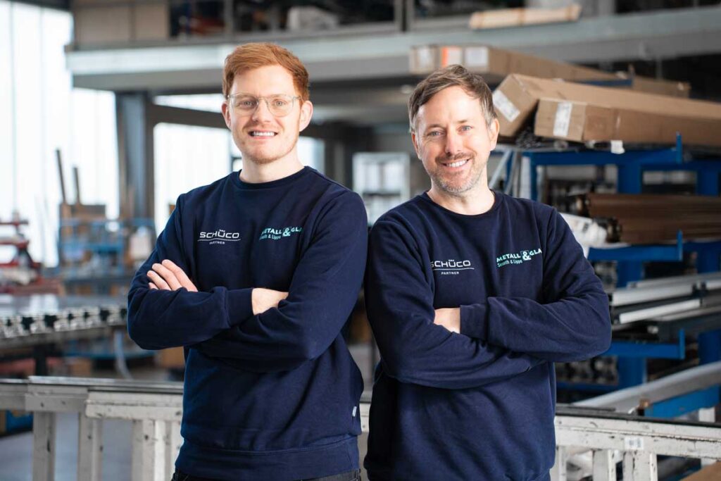 Philipp Sosath und Tobias Neuke stehen nebeneinander in der Metallwerkstatt