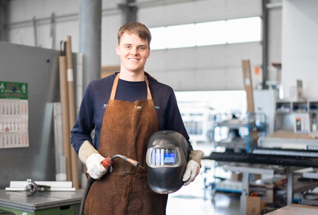 Azubi mit einem Schweißgerät in der Werkstatt